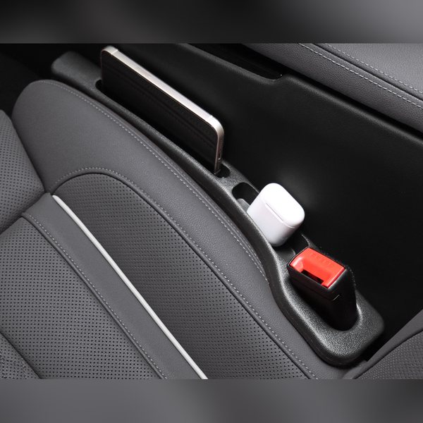 Relleno en un interior negro sujetando un celular y unos audífonos
